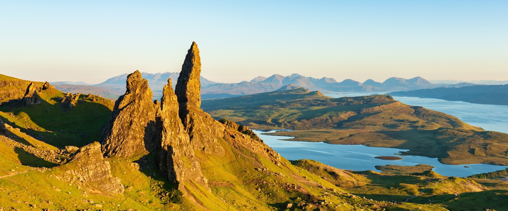 Sunrise over rocks, mountains and ocean