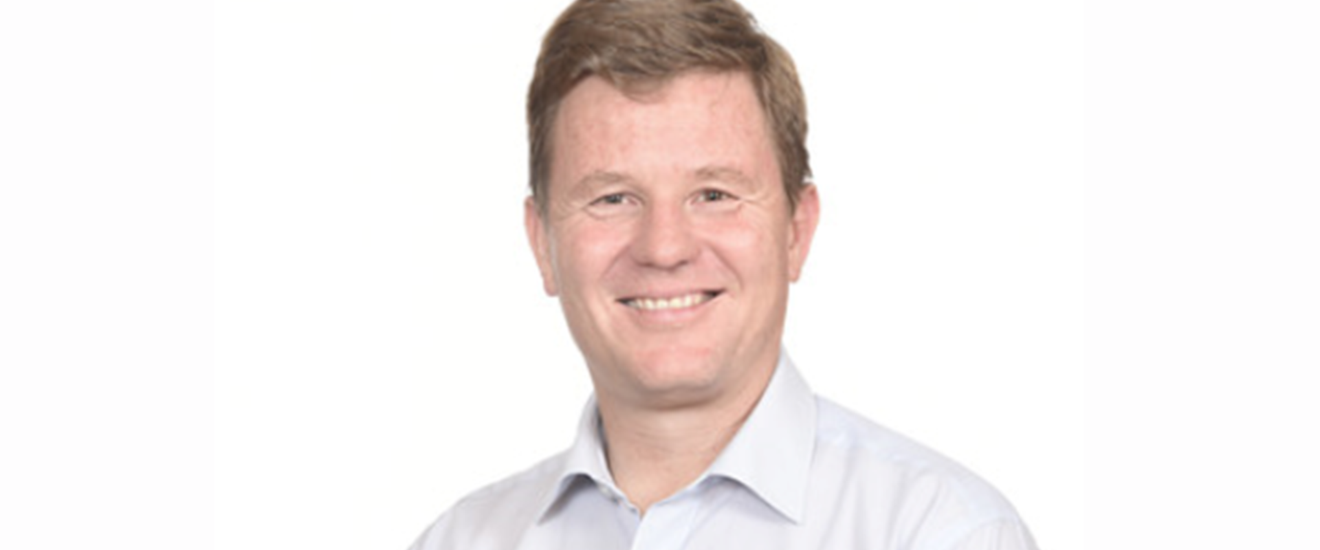 A person wearing a light button‑down shirt, positioned against a plain white background.