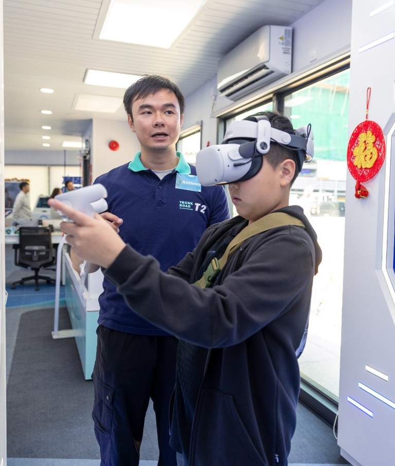 young boy with virtual reality visor with a man explaining something to him