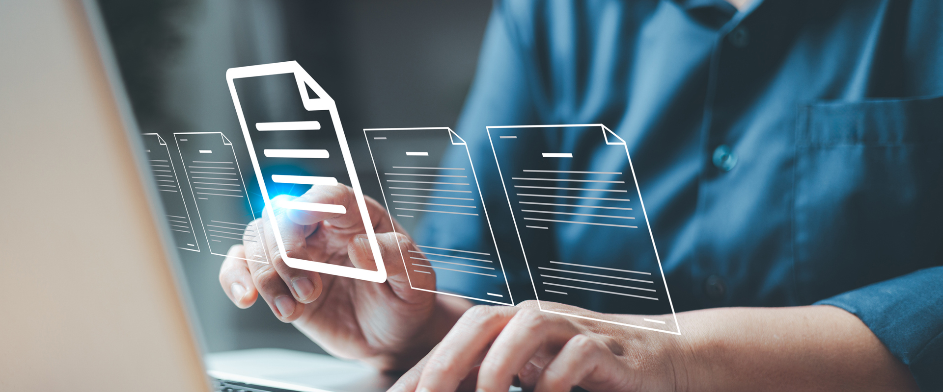 laptop with man's hand touching it and transparent digital documents in front of the screen