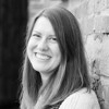 Black and white photo of a white woman with shoulder length brown hair smiling at the camera