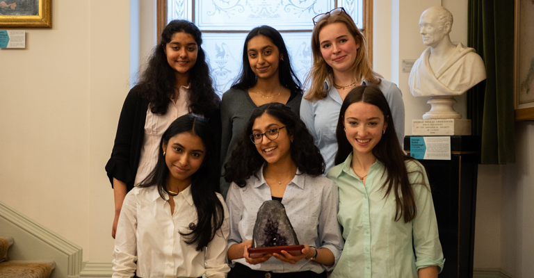 six young women holding a crystal trophy