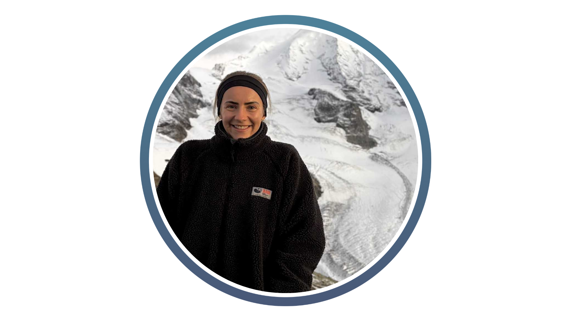A person in a dark fleece jacket and headband smiles in front of a snowy mountain landscape. The image is bordered by a blue circle, conveying a cool, serene tone.