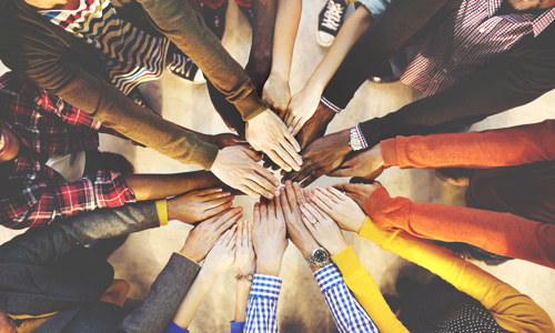 Ten pairs of hands joining together to create a rainbow circle