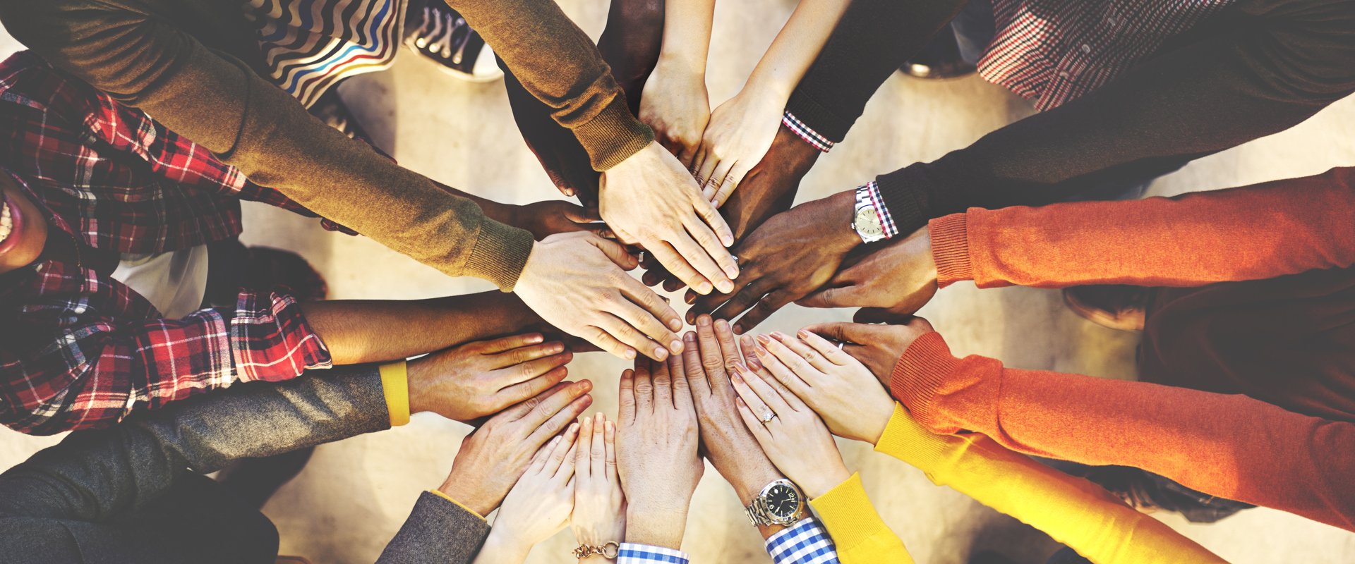 Ten pairs of hands joining together to create a rainbow circle