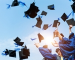 Graduates throwing graduation caps in the air