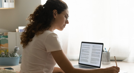 Image: individual person working at a desk with open laptop