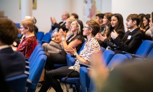 Attendees at a conference clapping in appreciation, reflecting a positive atmosphere and active participation in the event.