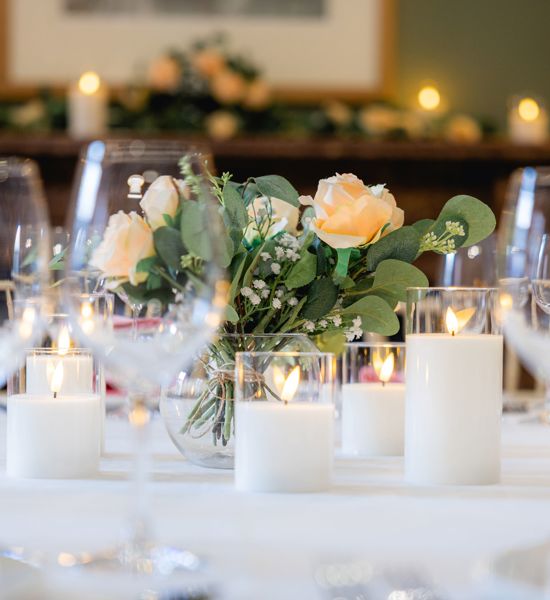 Lower Library Round Table Dining Setup with flower centrepiece and candles.