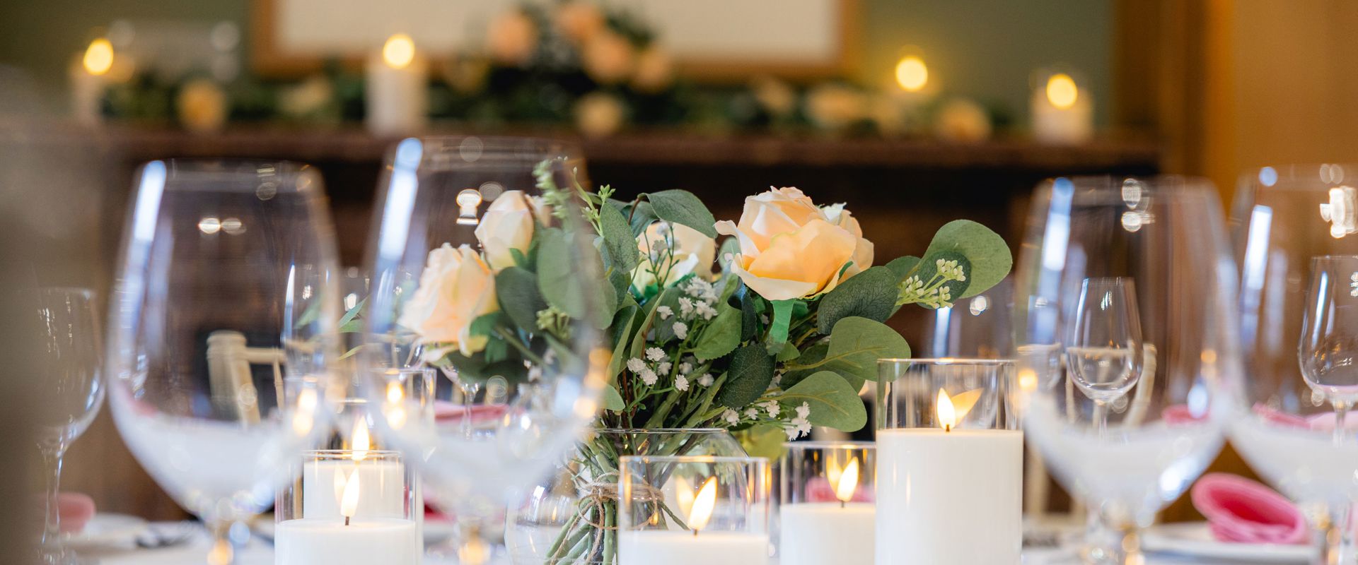 Lower Library Round Table Dining Setup with flower centrepiece and candles.