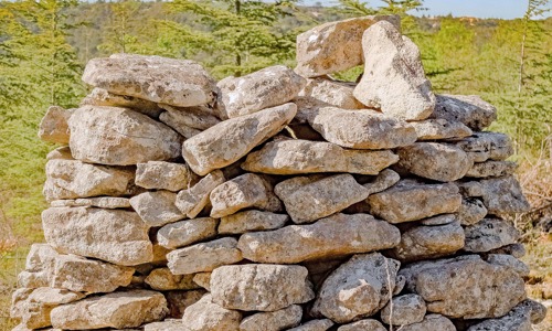 A pile of sandy coloured stones like a dry stone wall