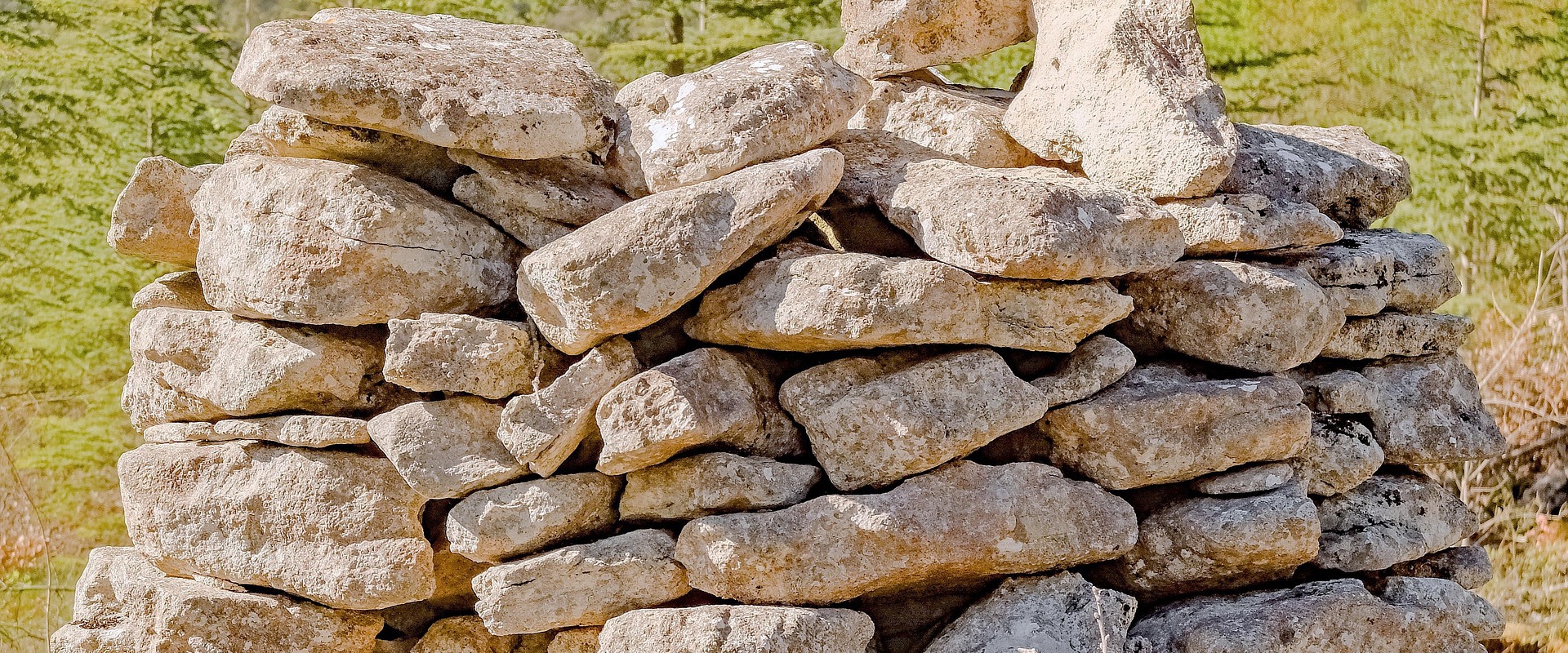 A pile of sandy coloured stones like a dry stone wall