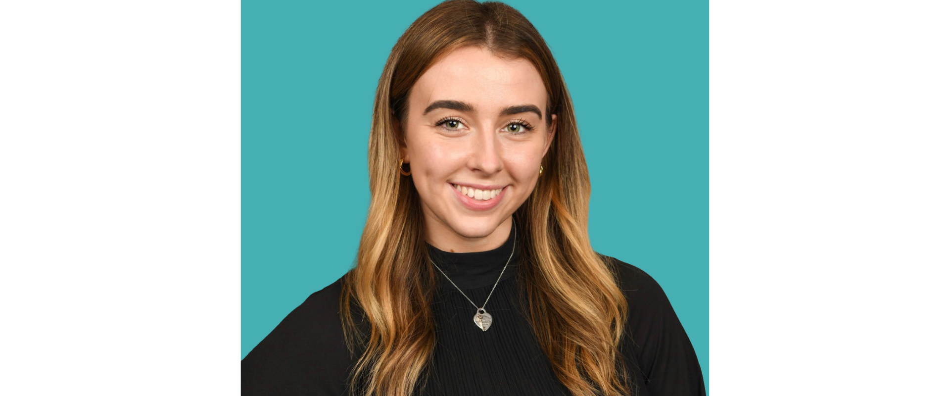 Professional headshot of a person facing forward against a teal background, wearing a black high-neck top and a small pendant necklace, with long hair and a neutral studio-style composition.