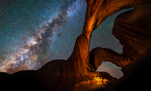 Milky Way Galaxy behind Double Arch sandstone rock formation in Arches, National Park, Utah