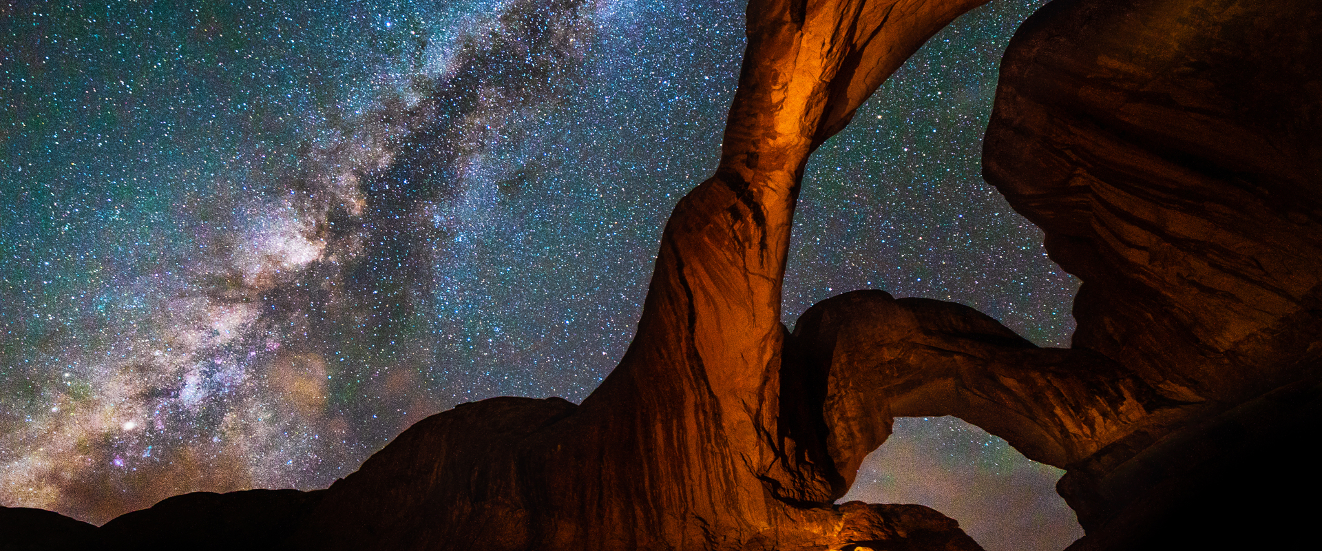 Milky Way Galaxy behind Double Arch sandstone rock formation in Arches, National Park, Utah