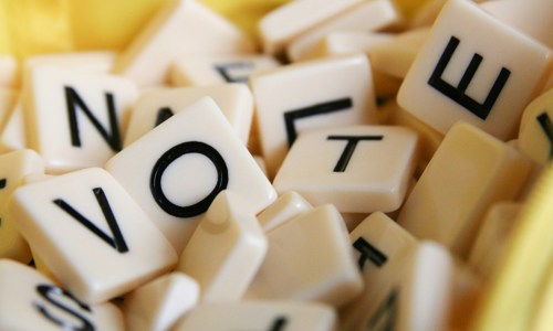 A pile of Scrabble tiles spelling out the word VOTE