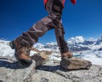 Person in walking boots stepping over rocks