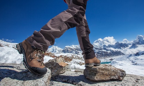 Person in walking boots stepping over rocks