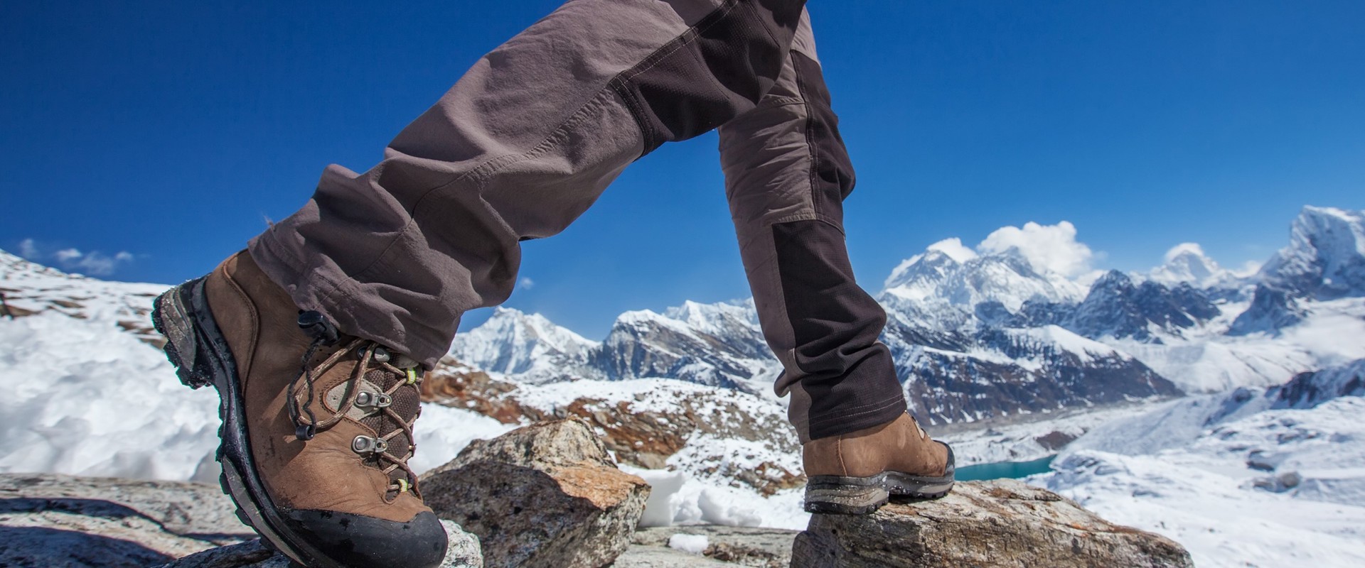 Person in walking boots stepping over rocks