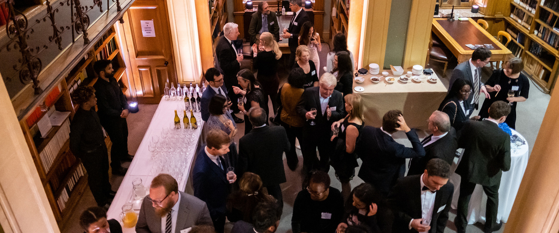 people at an event holding drinks and chatting