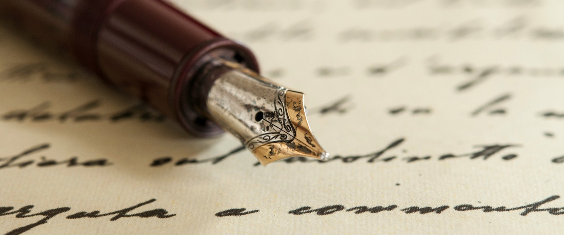 A sheet of paper with black handwriting on which rests the nib and first half of a brown fountain pen