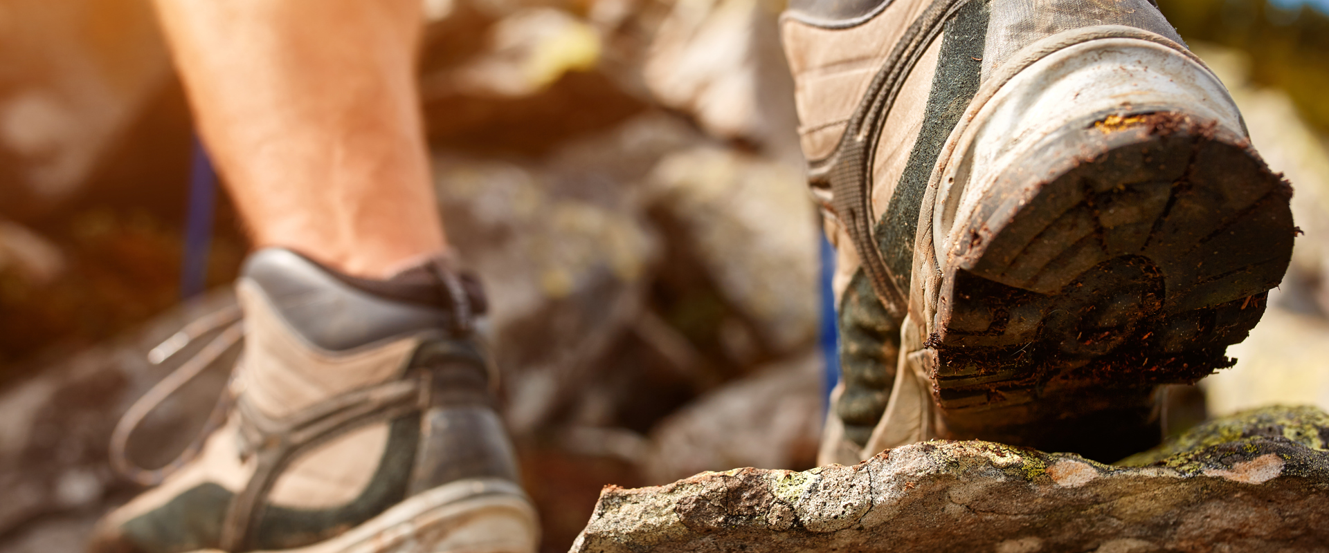 Person in walking boots stepping over rocks