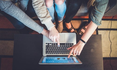 Group pointing at a laptop screen