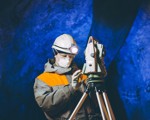 Woman in hardhat in mine assessing engineering equipment