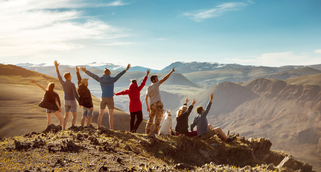 Friends stood on a mountaintop cheering