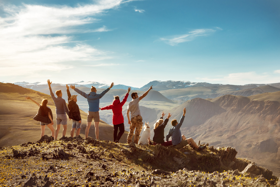 Friends stood on a mountaintop cheering