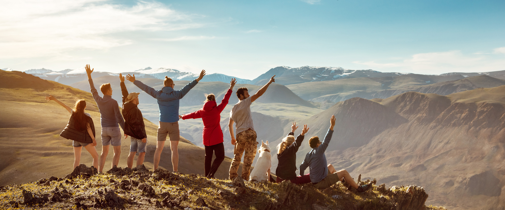 Friends stood on a mountaintop cheering