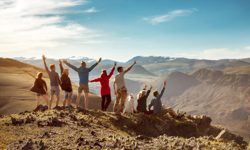 Friends stood on a mountaintop cheering