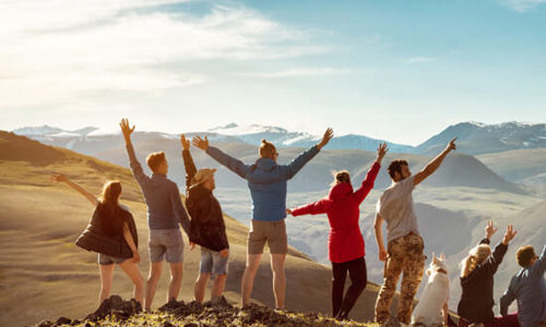 Friends stood on a mountaintop cheering