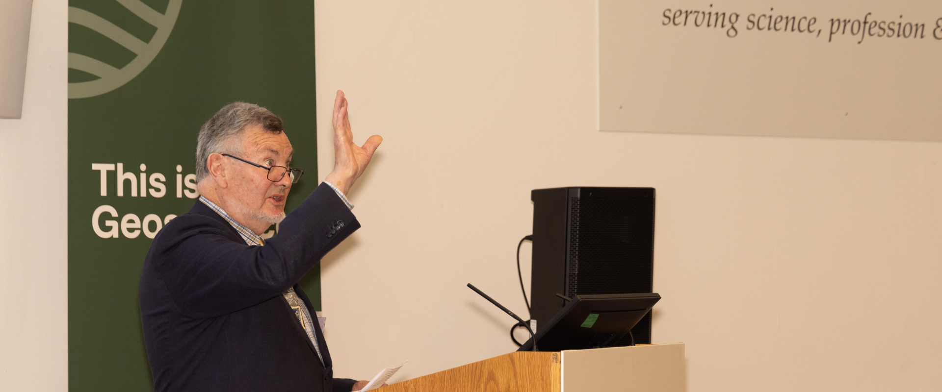 Professor Rory Mortimore speaks from a lectern in the Geological Society's lecture theatre