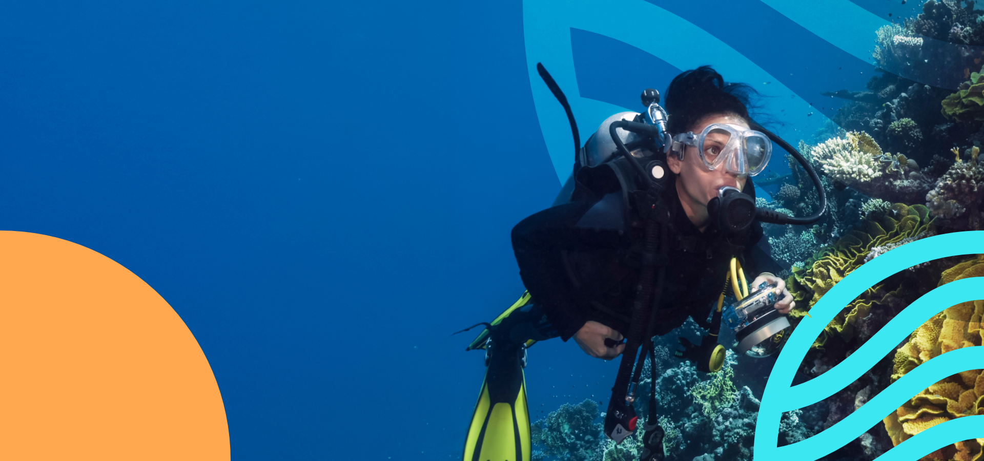 A diver is underwater near vibrant corals, equipped with scuba gear and a camera, surrounded by a deep blue ocean