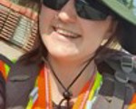 Photo of a Geologist at work, smiling and wearing a hat