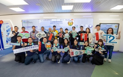 a group of people from Hong Kong, stood in front of a white board, holding a variety of banners 