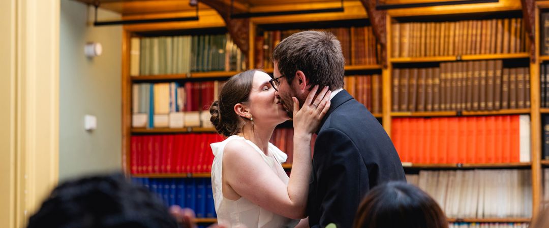 The bride and groom were kissing after the wedding ceremony