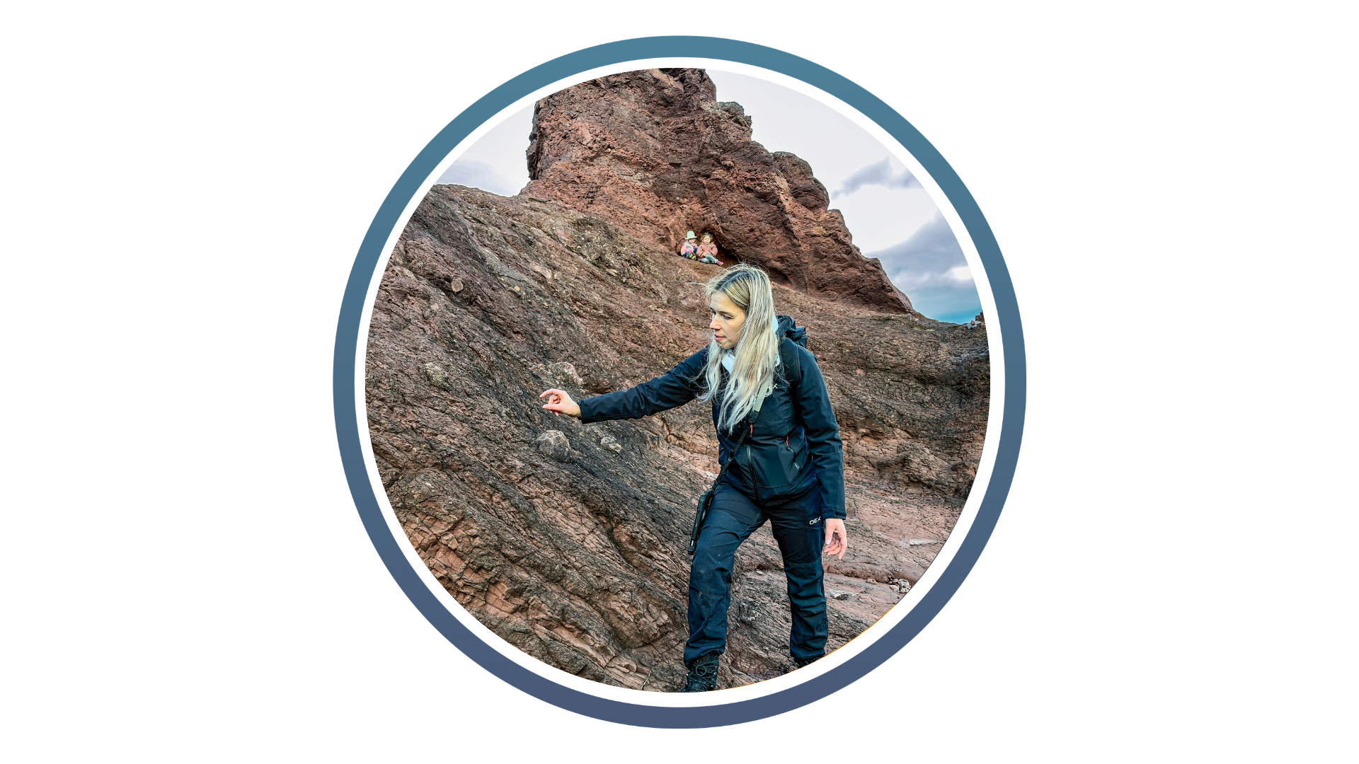 Woman in outdoor gear climbing rocky terrain with two children visible in a rock crevice above, under a cloudy sky.